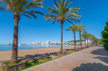 Ibiza güneş parlar Sant Antoni de Portmany, Sahilde yürüyüşe ana sahil boyunca veya kum. Kasım beach sıcak sabah ışığında.