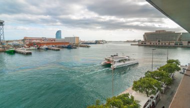 Körfezde Port Vell marina Catalonia Barcelona yakınındaki katamaran geçiyor, insanlar daha düşük düzey yürüyüş. Rıhtımlar üzerinde iyi öğleden sonra.