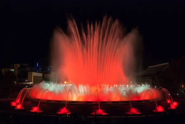 Colorful large fountain in Barcelona Spain turns on at night & provides entertainment for all ages on a warm October evening.