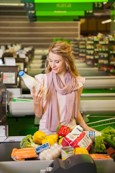 Молода жінка купує їжу в продуктовому магазині — стокове фото