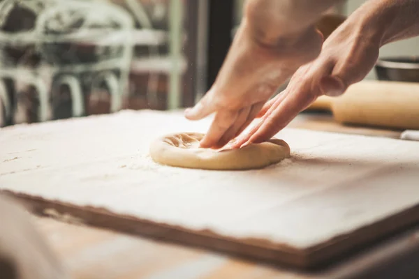 Hands preparing dough basis for pizza — Stock Photo, Image