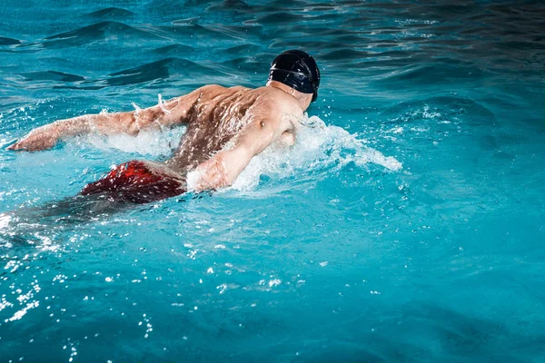 Giovane uomo sano con il corpo muscolare nuota — Foto Stock