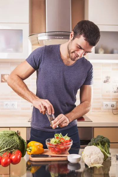 Jovem preparando comida em casa — Fotografia de Stock