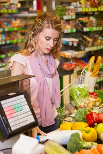 Mujer joven comprando comida en el supermercado — Foto de Stock