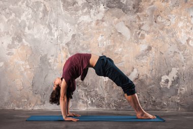 Genç adam kentsel arka planda Yoga ya da pilates egzersiz yaparak. 