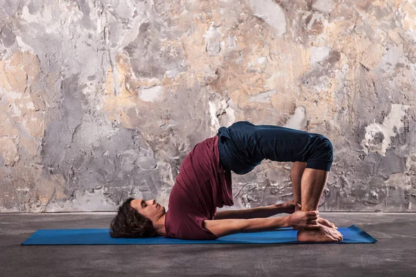 Giovane uomo che pratica yoga in uno sfondo urbano — Foto Stock