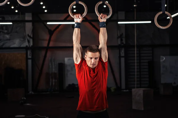 Atleet trainen van zijn spieren op ringen — Stockfoto
