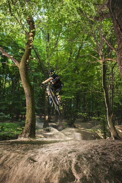 Homem motos na floresta verde . — Fotografia de Stock