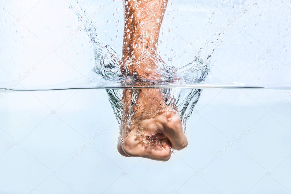 Male fist through the water 