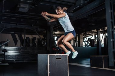 Sportif kız kutuların içinde jimnastik salonu üzerinden atlama