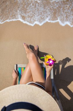 Güzel plajda şezlong üzerinde oturan kadın 