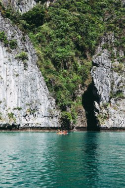 Bir kayık büyük kayanın önünde turistlere 