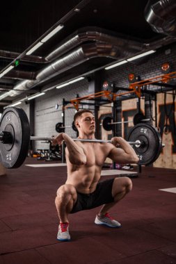Genç adam bir halter kaldırma crossfit salonunda.