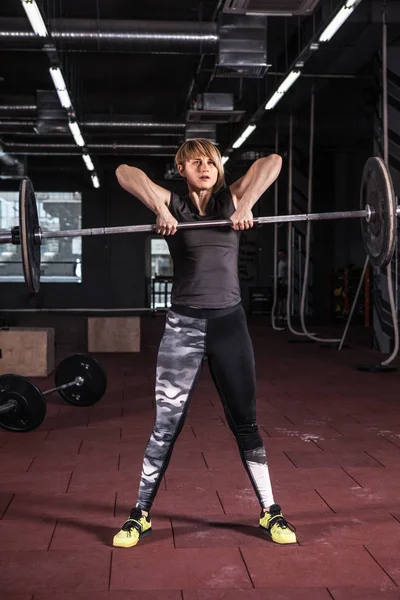 Strong woman lifting barbell as a part of crossfit exercise rout — Stock Photo, Image