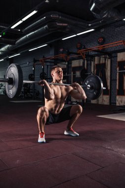Genç adam bir halter kaldırma crossfit salonunda.