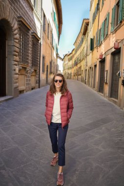 Tipik boş İtalyan caddesinde mutlu genç bir kadın..