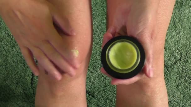 Woman putting ointment cream on bad injured knee — Stock Video