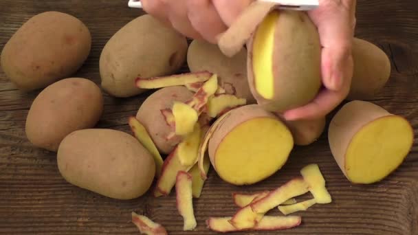 Tangan mengupas kentang, pandangan atas — Stok Video