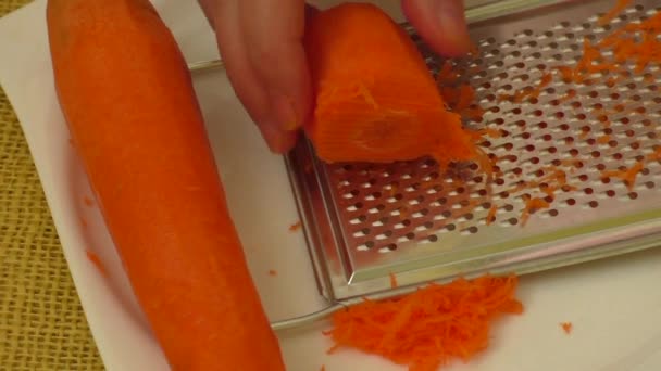 Female grating carrot on grater — Αρχείο Βίντεο