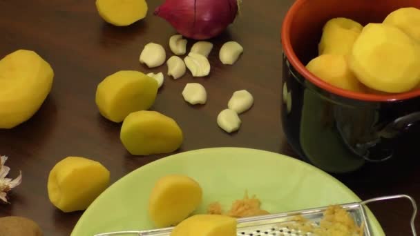 Ahşap masa ıslak zeminde yeni soyulmuş patates — Stok video