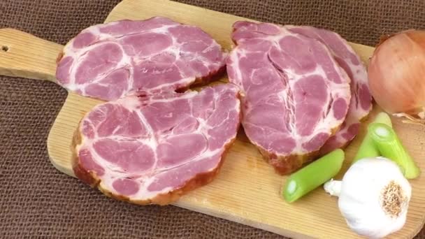 Gros plan d'une planche à découper avec du porc fumé — Video