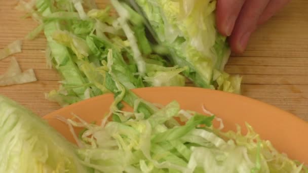 Fresh green iceberg lettuce with knife on wooden chopping board — Stock Video