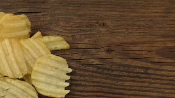 Rippled potato chips on a wooden background — Stock Video