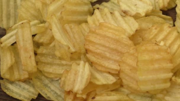 Wellige Kartoffelchips auf einem hölzernen Hintergrund — Stockvideo