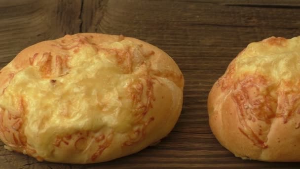 Baguette con queso derretido sobre fondo de madera — Vídeos de Stock