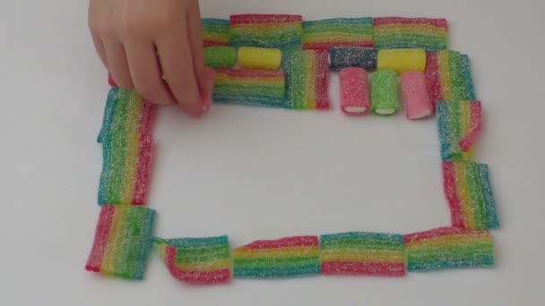 Фруктові желе цукерки покриті цукром на білому фоні — стокове відео