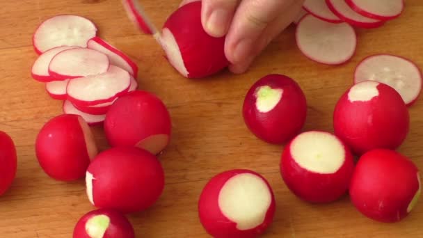 Slicing radish on a rustic wooden table — Stock Video