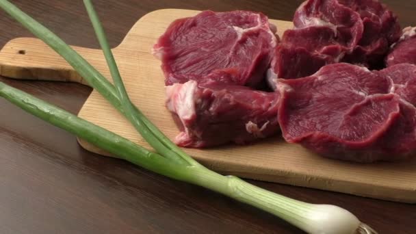 Carne fresca cruda en placa de corte de madera — Vídeo de stock