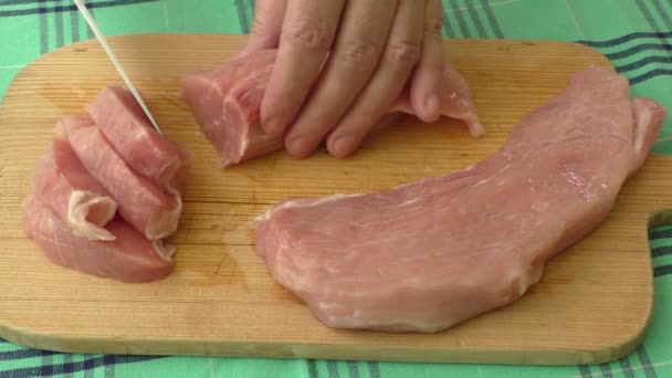 Fresh pork on the chopping board is cut into pieces — Stock Video