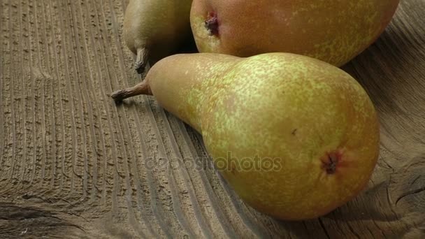Tre mogna saftiga päron på ett mörka träbord — Stockvideo