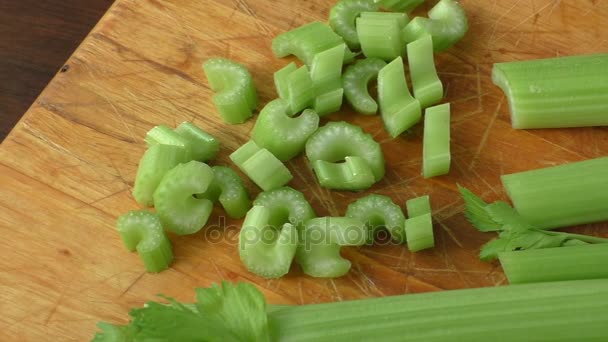 Apio picado en tabla de cortar de madera — Vídeos de Stock