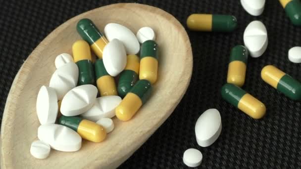 Surtido de píldoras, tabletas y cápsulas de medicamentos farmacéuticos en cuchara de madera — Vídeo de stock