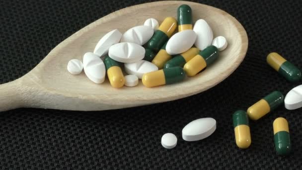 Асорті фармацевтичних препаратів таблетки, таблетки і капсули на дерев'яній ложці — стокове відео
