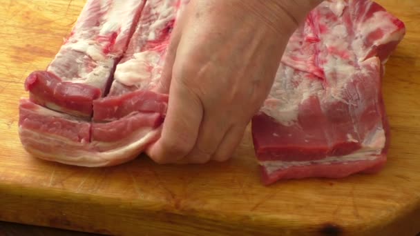 Сырые свиные ребрышки на деревянной тарелке — стоковое видео