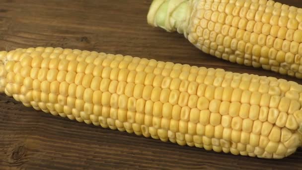 Palomitas de maíz fresco en la superficie de madera vieja. Maíz en una tabla de madera — Vídeos de Stock