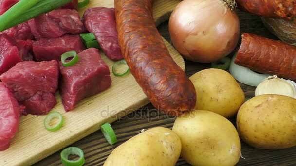 Ingredientes crudos para estofado, gulash o sopa. Carne fresca picada cruda en una tabla de cortar de madera con especias y verduras . — Vídeo de stock