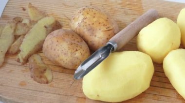 Patates soyma ve yumru, ahşap masanın üzerinde yatan kabukları