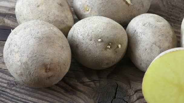 Patatas sobre fondo de madera. Patatas orgánicas crudas sin pelar — Vídeo de stock