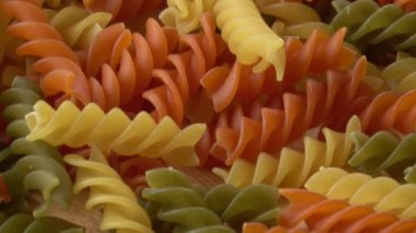 Pişmemiş üç renkli İtalyan makarna. İtalyan makarna ahşap bir masa üzerine kurutulmuş. Renkli doğal makarna