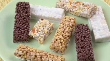 Çeşitli sağlıklı granola bar (müsli veya tahıl bar). Yeşil plaka üzerinde izole müsli barlar.