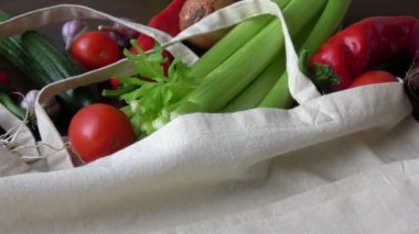 İçinde sebzeler olan bir poşet. Sıfır atık daha az plastik konsept kullanıyor. Taze sebzeler, ahşap masadaki pamuk kumaş torbalarında organik.