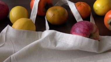 Meyveli eko çanta. Sıfır atık daha az plastik konsept kullanın. Taze meyveler eko pamuklu kumaş çuvalları içinde ahşap masa üzerinde organik.