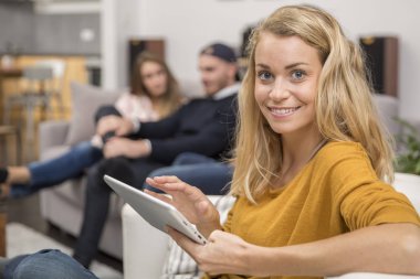 genç kadın kanepe tablet ile oturuyor