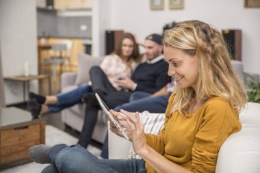 genç kadın kanepe tablet ile oturuyor