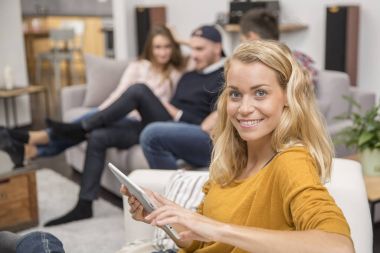 genç kadın kanepe tablet ile oturuyor