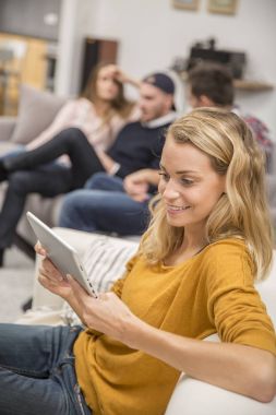 genç kadın kanepe tablet ile oturuyor